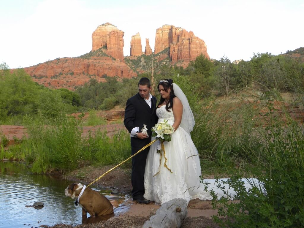 bride, groom and best pet at their wedding by the water at Red Rock Crossing in Sedona